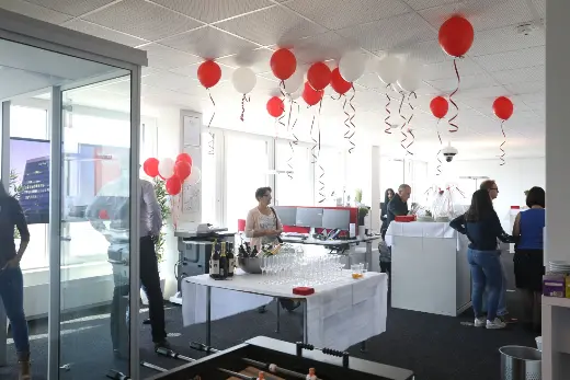 Office celebration with red and white balloons – Arclap construction camera